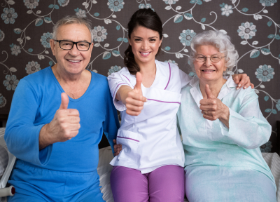 group of seniors and caregiver doing thumbsup